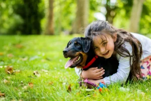 Happy child hugging a dog in a clean backyard in Charlotte, NC—The Scoop Force pet waste removal.